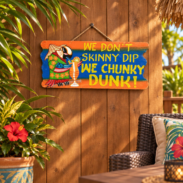 A hand-painted wooden hanging sign with a tropical theme. The sign features a cartoon parrot wearing a green floral shirt and straw hat, holding a drink.  At World of Decor NZ