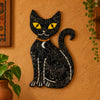 A black mosaic cat figurine with yellow eyes, a white crescent moon on its chest, and a small orange collar, photographed against a plain light gray background. Mosaic Wall Hanging-Panther Cat Wall Art, Affirmations & Hangings at World Of Decor NZ